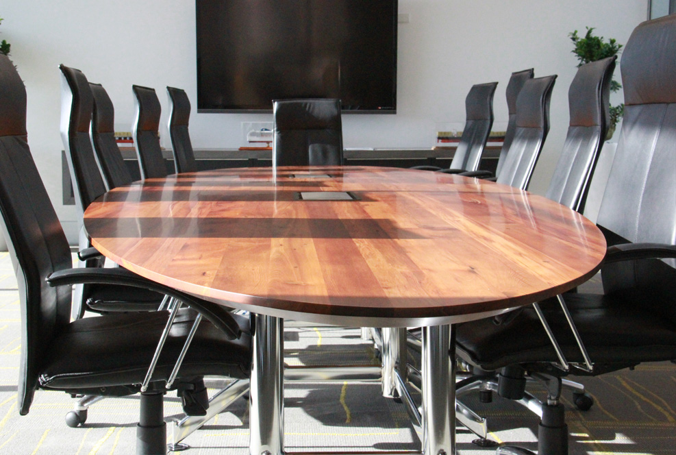 Custom recycled-timber boardroom table with black meeting chairs